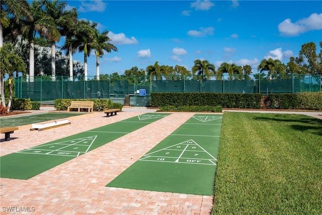 view of home's community featuring fence, a lawn, and shuffleboard