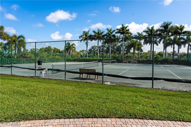 view of sport court with fence and a yard