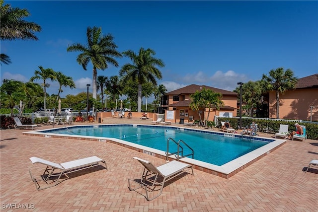 pool featuring fence and a patio