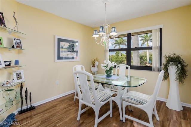 dining area featuring an inviting chandelier, baseboards, and wood finished floors