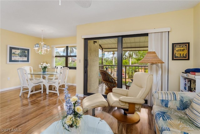 sitting room featuring baseboards, a chandelier, and wood finished floors