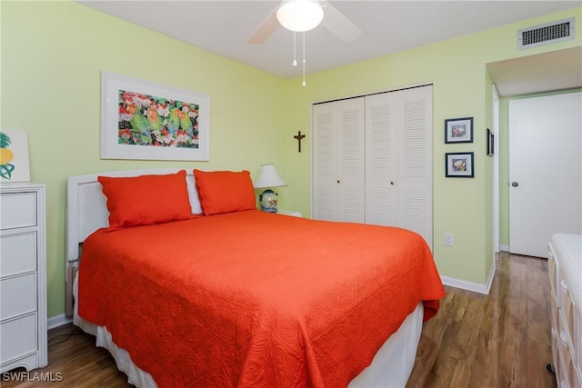 bedroom featuring wood finished floors, a ceiling fan, visible vents, baseboards, and a closet