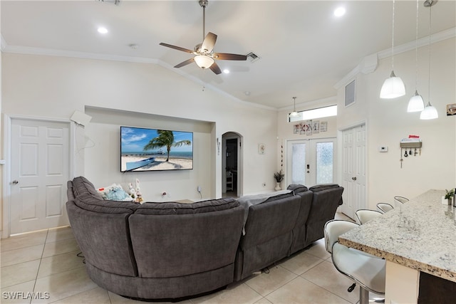 living room with arched walkways, light tile patterned floors, vaulted ceiling, french doors, and ornamental molding