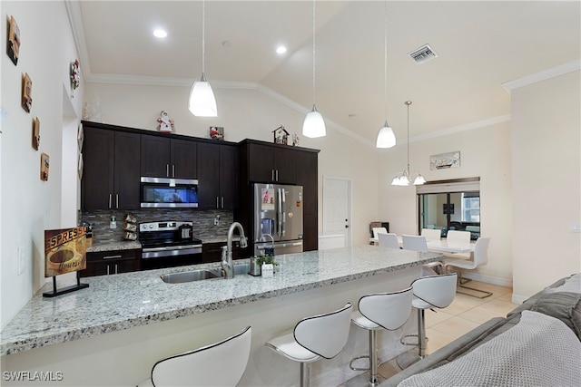 kitchen with appliances with stainless steel finishes, a sink, visible vents, and a kitchen breakfast bar