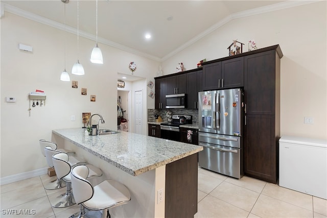 kitchen with appliances with stainless steel finishes, a sink, a kitchen breakfast bar, and light tile patterned floors