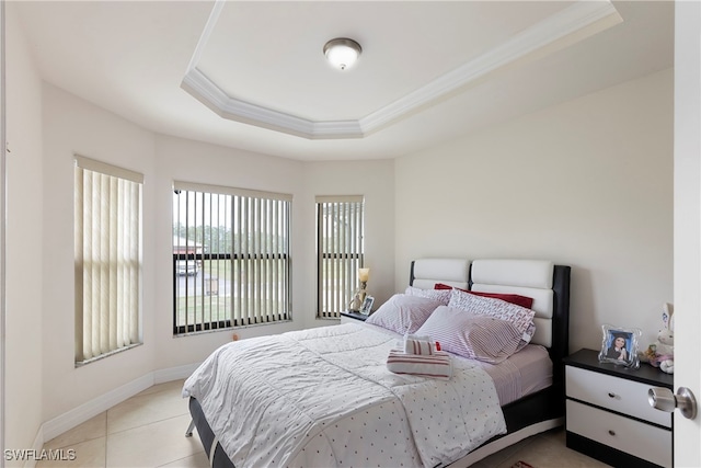 bedroom with baseboards, ornamental molding, a raised ceiling, and tile patterned floors