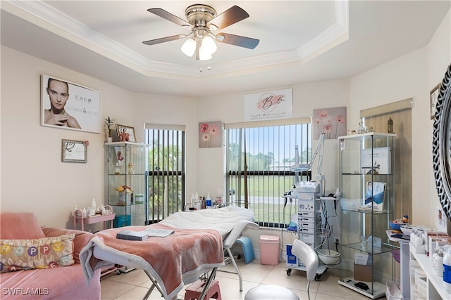 bedroom with light tile patterned floors, ceiling fan, a raised ceiling, and crown molding