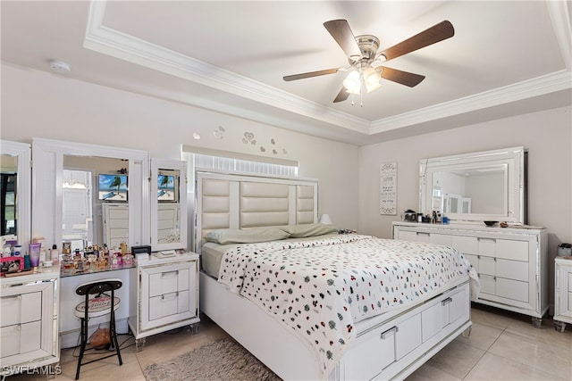 bedroom with a ceiling fan, ornamental molding, a tray ceiling, and light tile patterned flooring