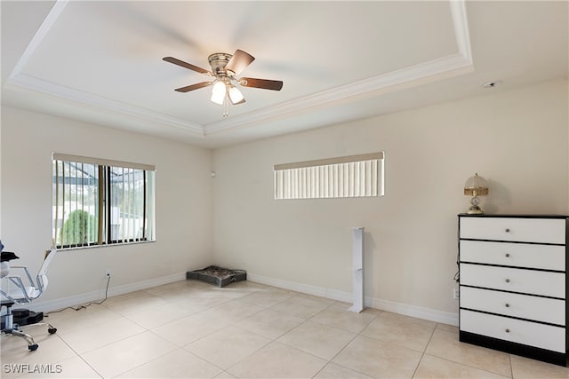 unfurnished office with a tray ceiling, crown molding, and light tile patterned floors