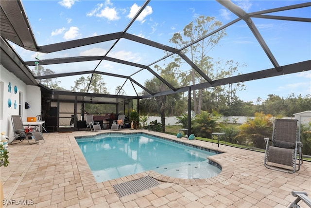 pool with a patio and glass enclosure