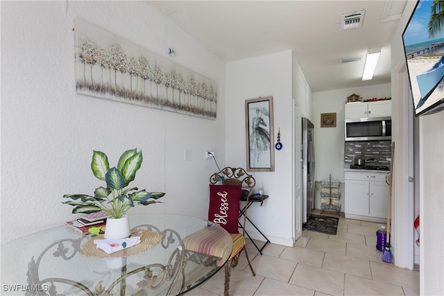 dining area featuring light tile patterned flooring and visible vents