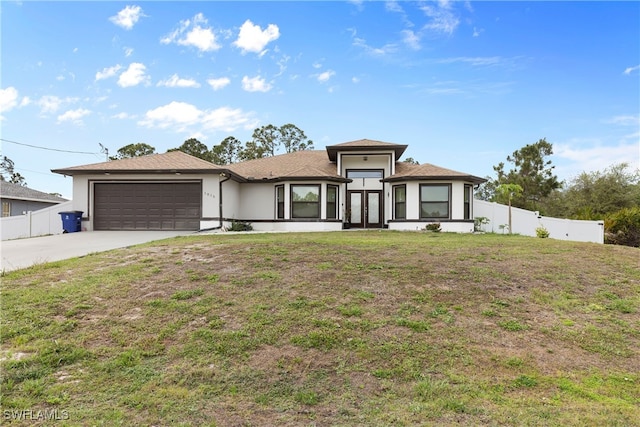 prairie-style house with concrete driveway, an attached garage, fence, and a front yard