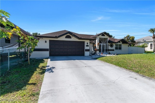 single story home featuring an attached garage, fence, driveway, stucco siding, and a front lawn