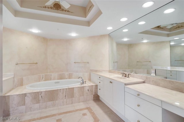 full bath featuring recessed lighting, a tray ceiling, a garden tub, and vanity