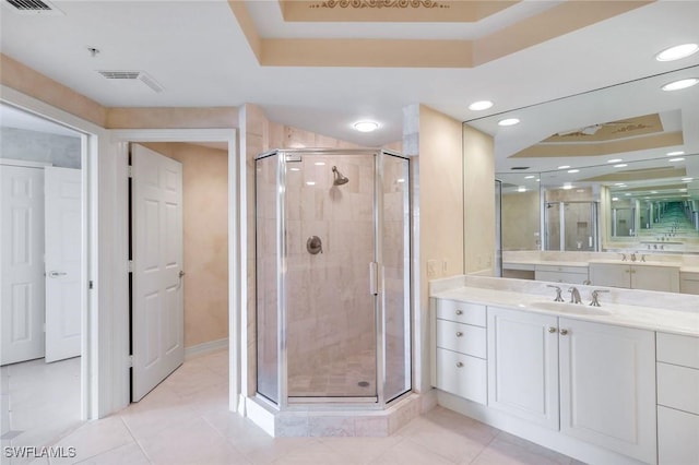 full bathroom featuring vanity, a shower stall, a raised ceiling, and tile patterned flooring