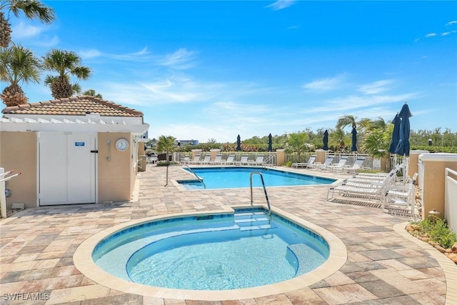 community pool featuring a pergola, a patio area, fence, and a hot tub