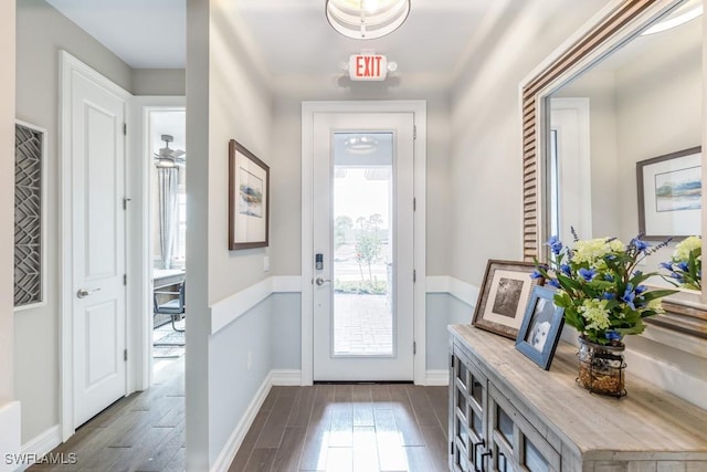 doorway to outside with a healthy amount of sunlight, baseboards, and dark wood finished floors