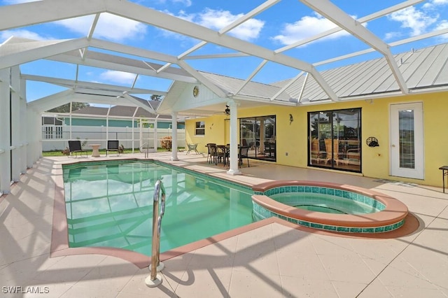 view of swimming pool with a pool with connected hot tub, a patio, fence, glass enclosure, and ceiling fan