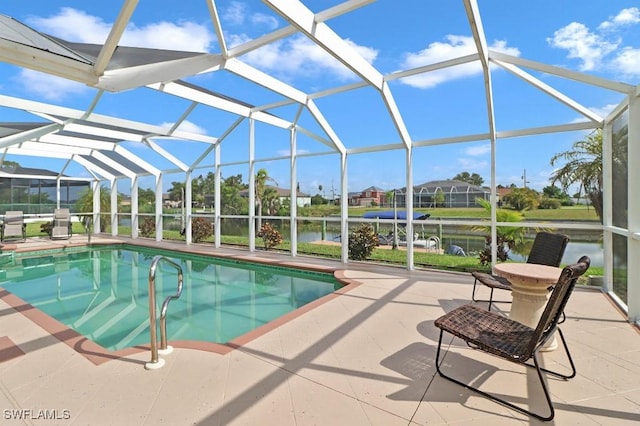 pool with glass enclosure, a patio, and a water view