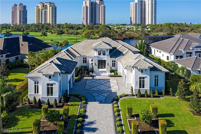 view of front of home featuring a front yard, decorative driveway, and stucco siding