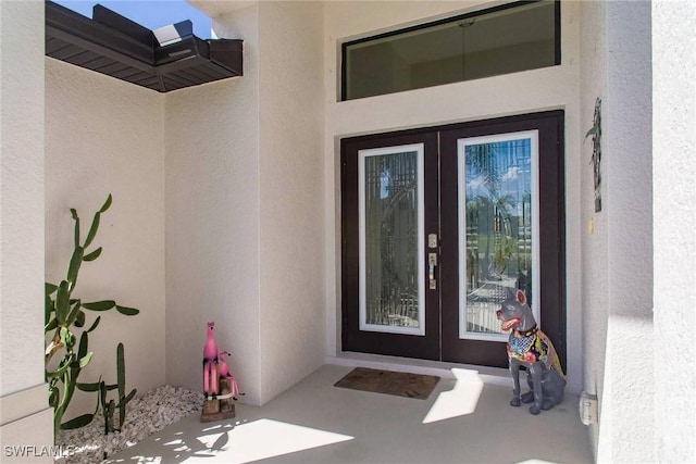 entrance to property featuring french doors and stucco siding