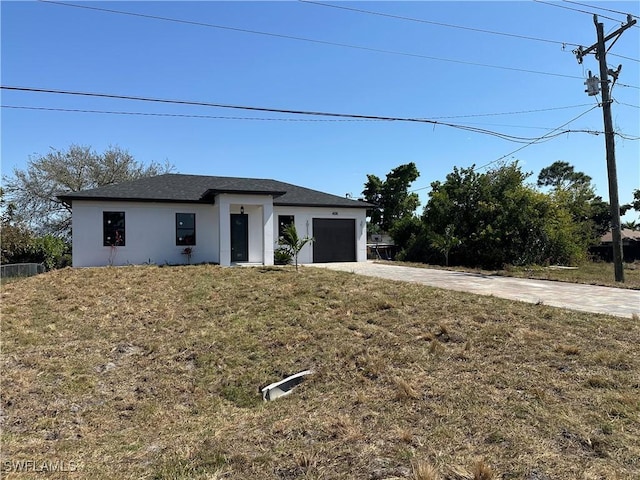 view of front facade with a garage, a front lawn, concrete driveway, and stucco siding