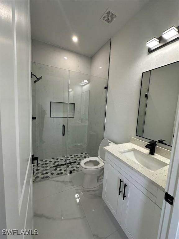 full bathroom with toilet, vanity, visible vents, marble finish floor, and a shower stall