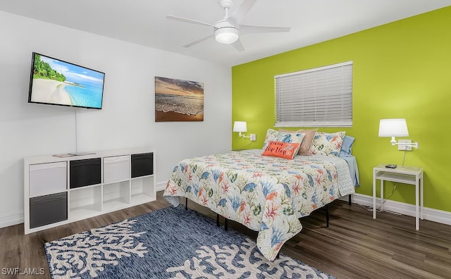 bedroom with a ceiling fan, baseboards, and wood finished floors