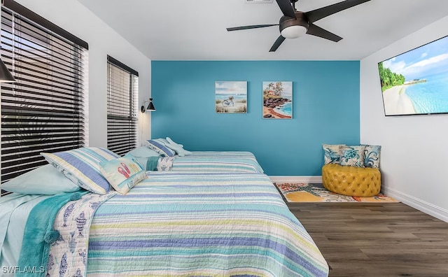 bedroom featuring wood finished floors, a ceiling fan, and baseboards