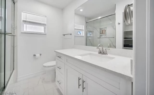 bathroom with toilet, vanity, baseboards, marble finish floor, and a marble finish shower