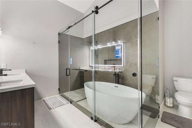 full bath featuring double vanity, a freestanding bath, toilet, a shower stall, and tile patterned flooring