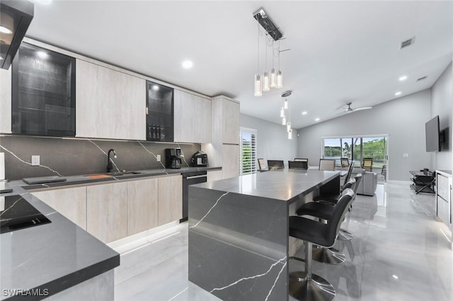 kitchen with black electric stovetop, visible vents, stainless steel dishwasher, light brown cabinetry, and modern cabinets