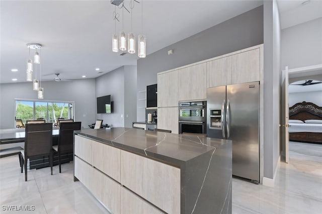 kitchen with double oven, a spacious island, stainless steel refrigerator with ice dispenser, and modern cabinets