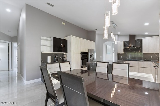 dining area with arched walkways, recessed lighting, a towering ceiling, visible vents, and baseboards