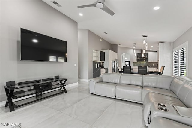 living area featuring visible vents, arched walkways, baseboards, ceiling fan, and recessed lighting