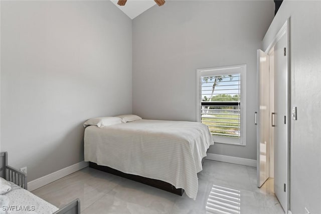 bedroom featuring lofted ceiling, a ceiling fan, and baseboards