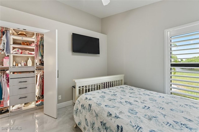 bedroom with concrete flooring and baseboards