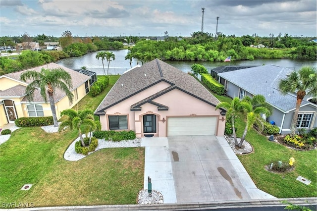 exterior space featuring an attached garage, a water view, driveway, stucco siding, and a front yard