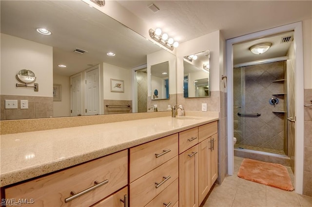 full bath featuring tile patterned flooring, toilet, vanity, visible vents, and a shower stall