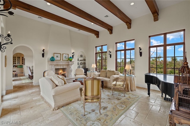 living room with stone tile floors, a high ceiling, a wealth of natural light, and a premium fireplace