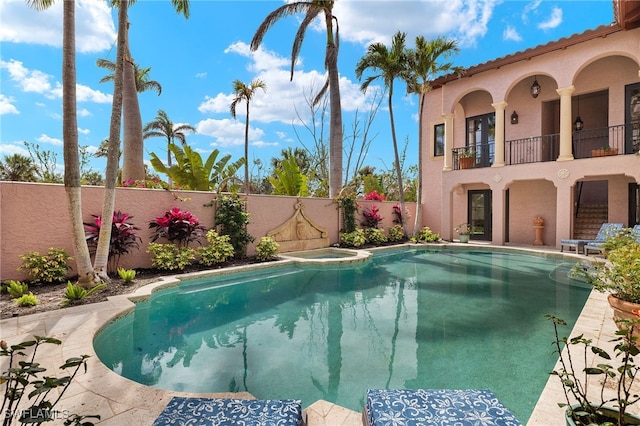 view of pool with a patio, a fenced backyard, and a pool with connected hot tub