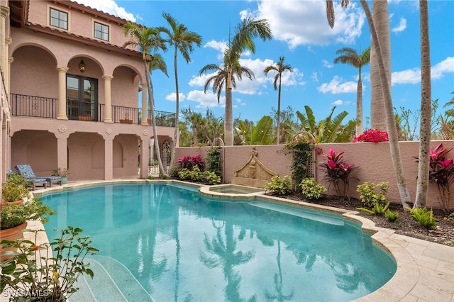 view of swimming pool with a pool with connected hot tub, a fenced backyard, and a patio