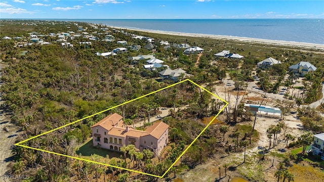 birds eye view of property with a water view and a beach view