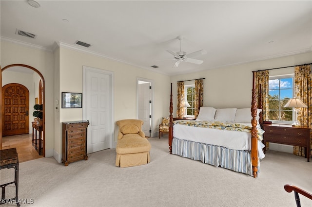 bedroom featuring arched walkways, carpet floors, ornamental molding, and visible vents