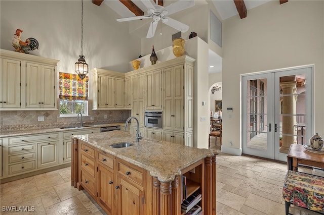 kitchen featuring cream cabinets, a sink, and stone tile floors