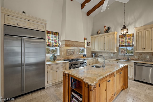 kitchen with high vaulted ceiling, premium appliances, cream cabinets, and a sink