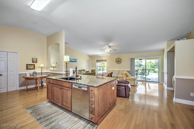 kitchen with a sink, a healthy amount of sunlight, open floor plan, light wood-style floors, and dishwasher