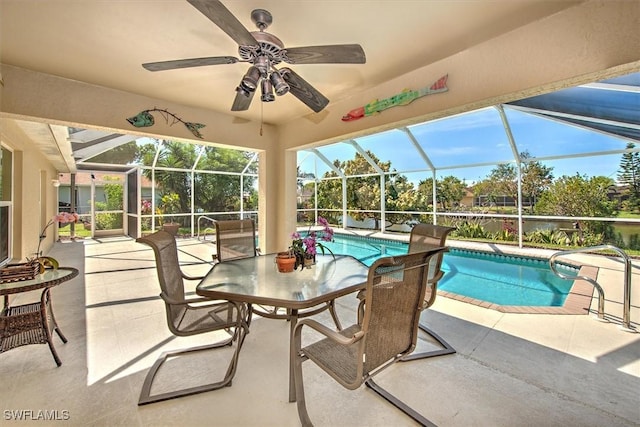 outdoor pool featuring a patio area, glass enclosure, and a ceiling fan