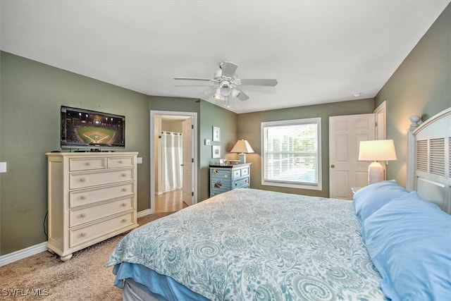 bedroom with light colored carpet, ceiling fan, and baseboards