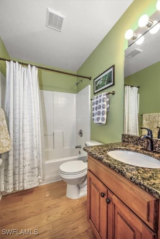 bathroom with vanity, wood finished floors, visible vents, and shower / bathtub combination with curtain